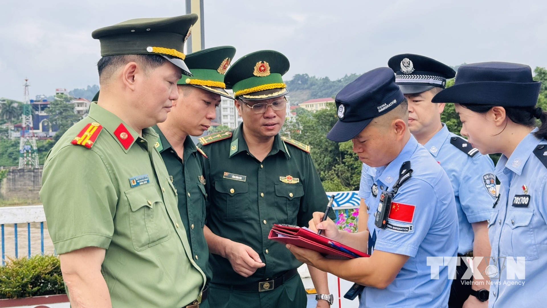 Ngày 29/6/2026, tại Cửa khẩu Quốc tế Lào Cai, Công an tỉnh Lào Cai phối hợp cùng Đồn Biên phòng Cửa khẩu Quốc tế Lào Cai tiến hành bàn giao 19 công dân Trung Quốc có hành vi lợi dụng mạng internet để hoạt động lừa đảo trực tuyến Cục Công an Châu Hồng Hà, (Trung Quốc). (Ảnh: TTXVN phát)